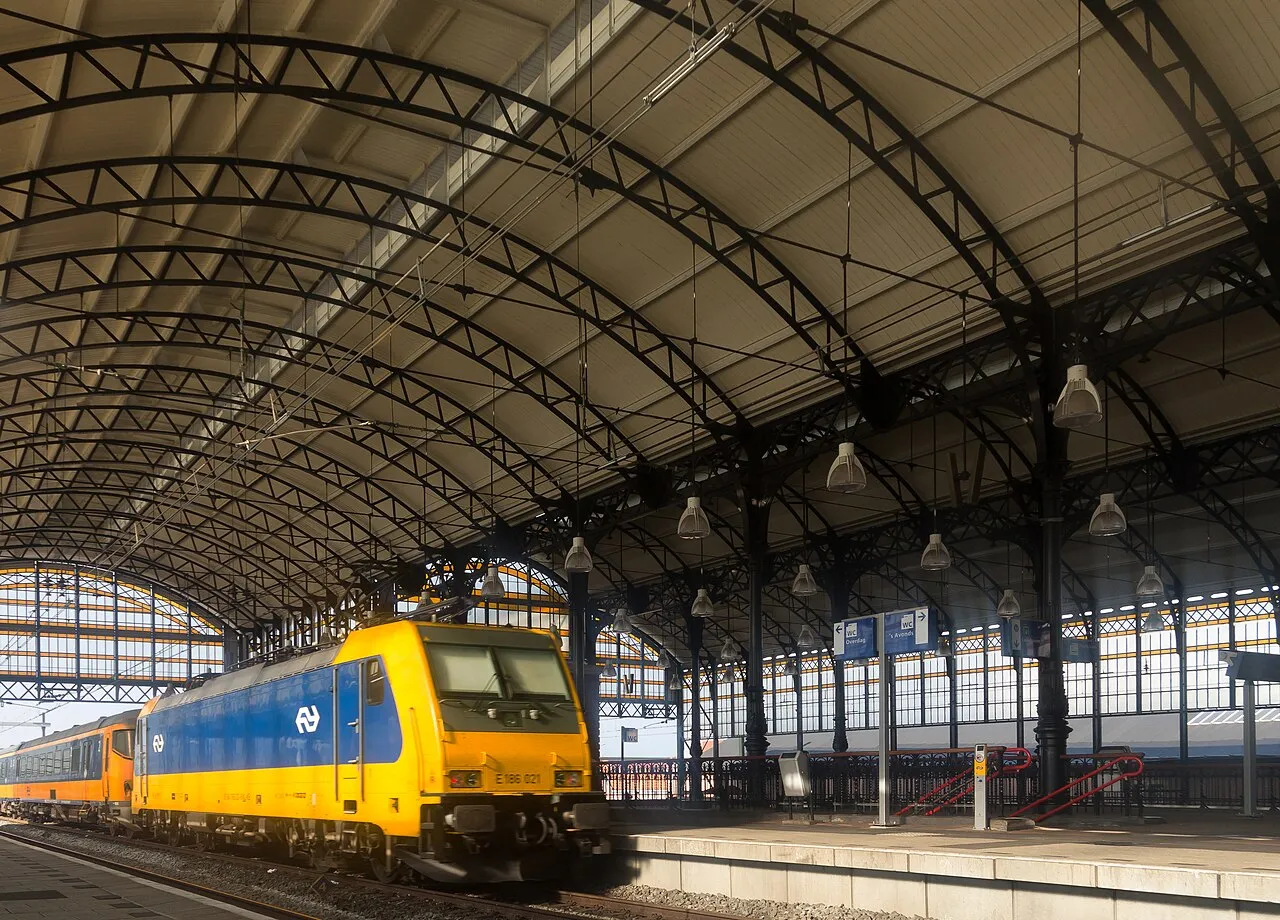 Een trein die wegrijdt bij station Den Haag Hollands Spoor, onder de perronoverkapping