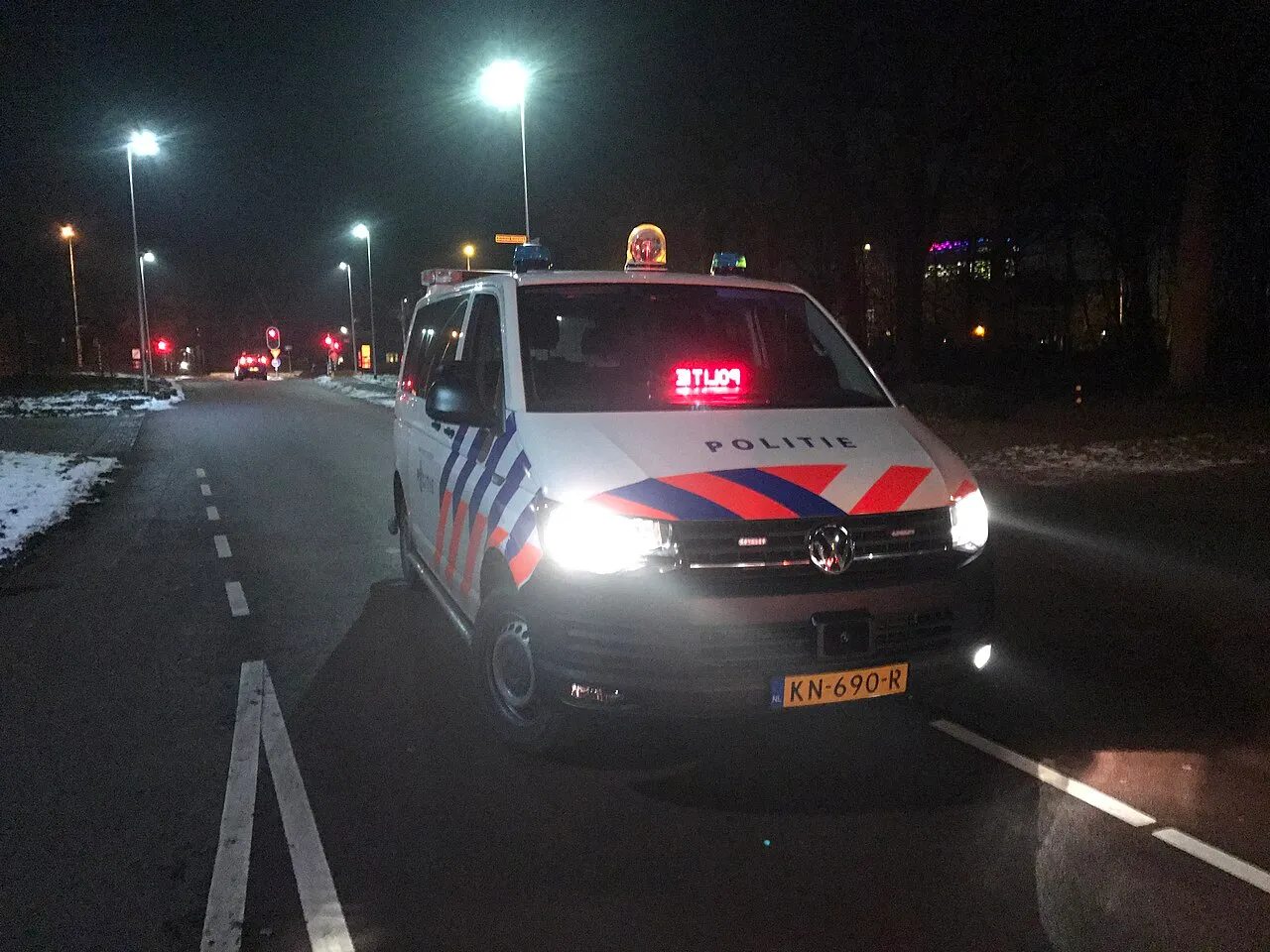 Nederlandse politie-bus met zwaailicht aan.