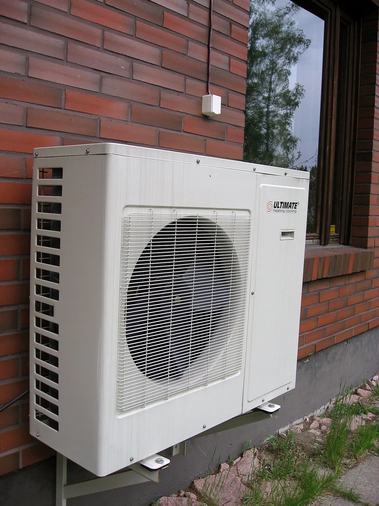 Buitenunit van een warmtepomp aan een buitenmuur