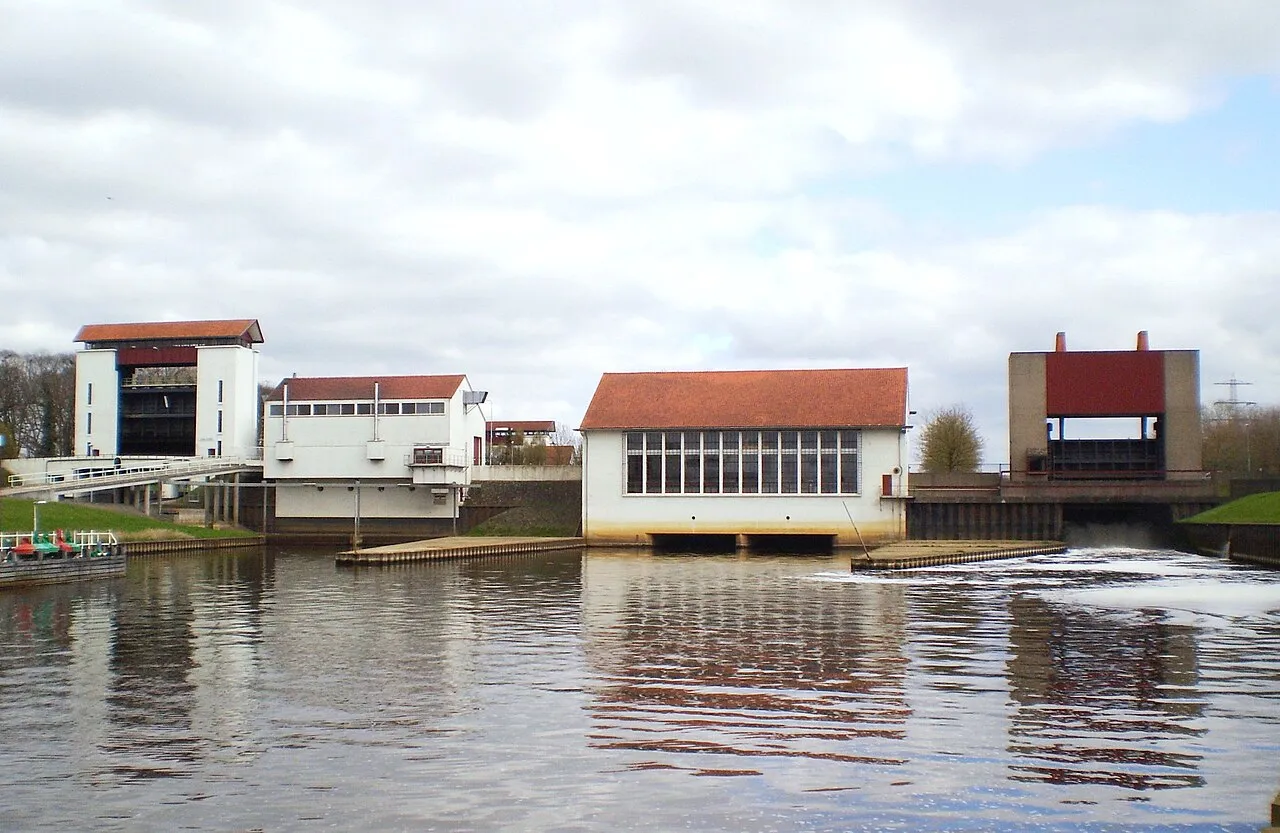 Het sluizencomplex bij Eefde aan het Twentekanaal, met sluistorens en een stuw, gezien over het water.